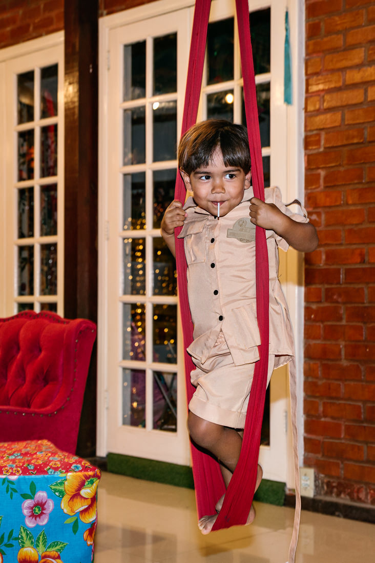 menino de 3 anos com pirulito na boca se equilibra em pano