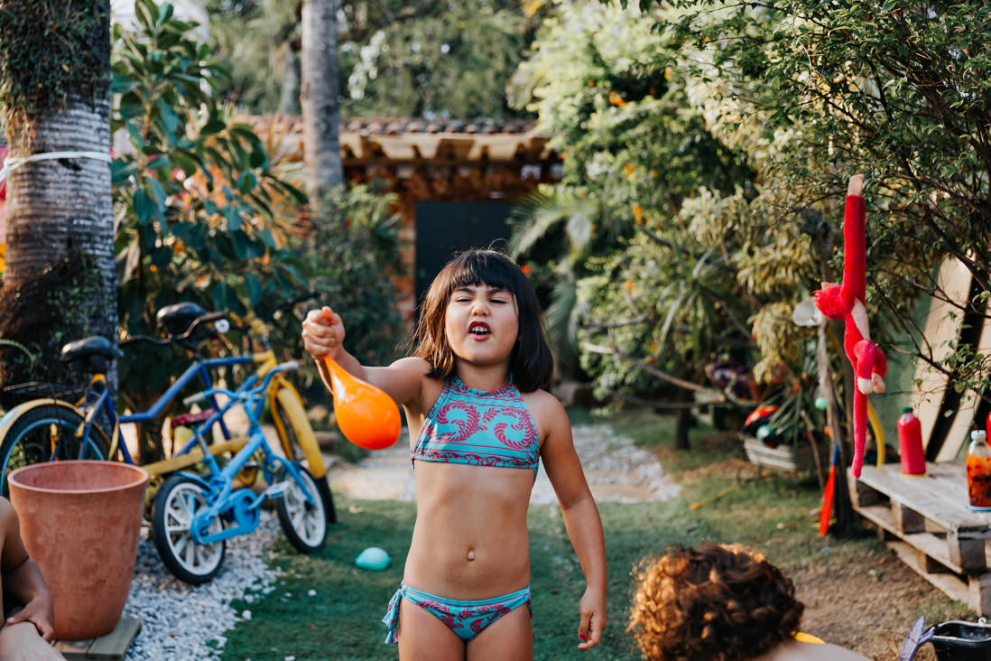 menina de biquino segura bola de gas cheia de agua dentro