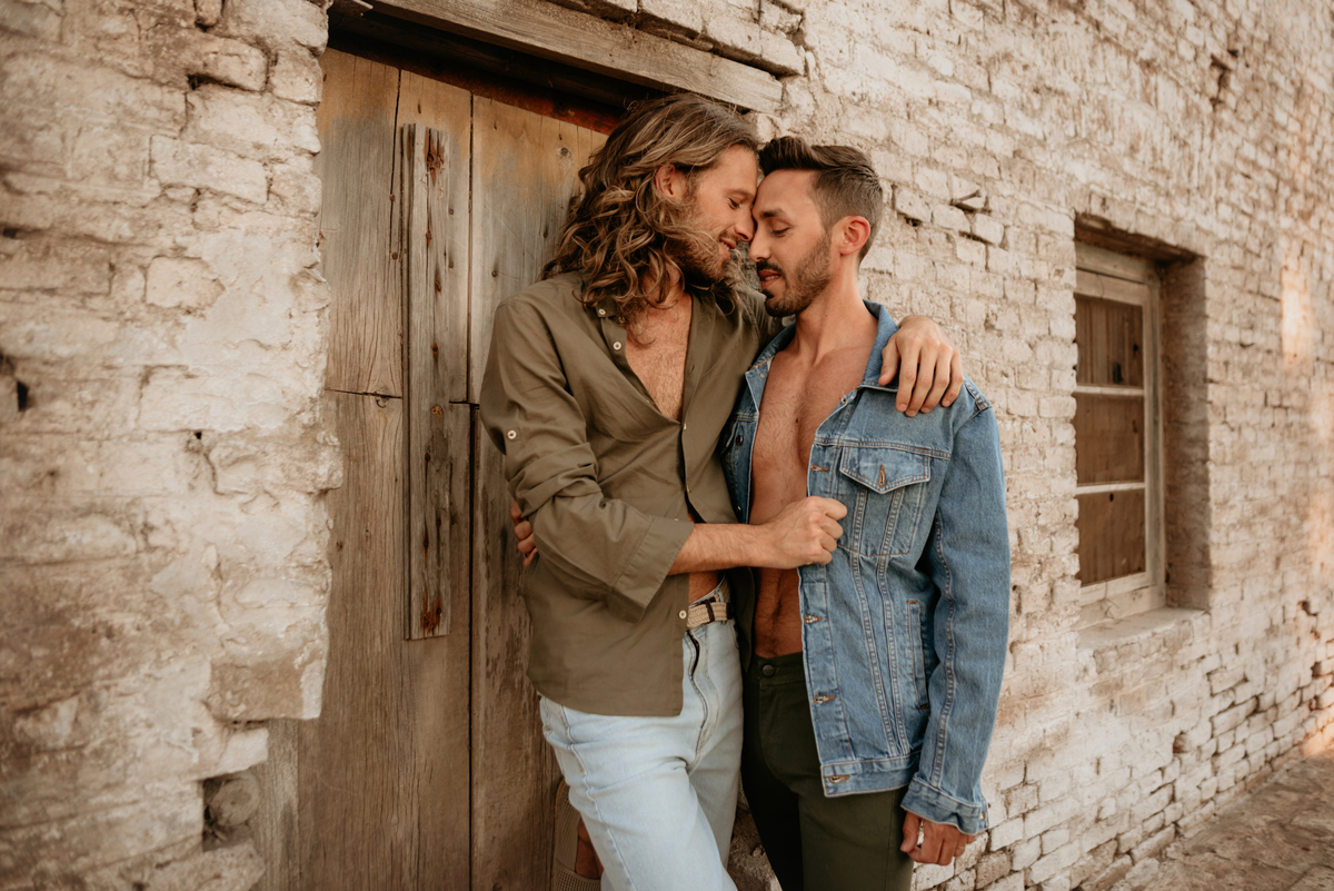 Pareja de hombres. Amor. Conexión. Modelos masculinos. Pareja sobre puerta.