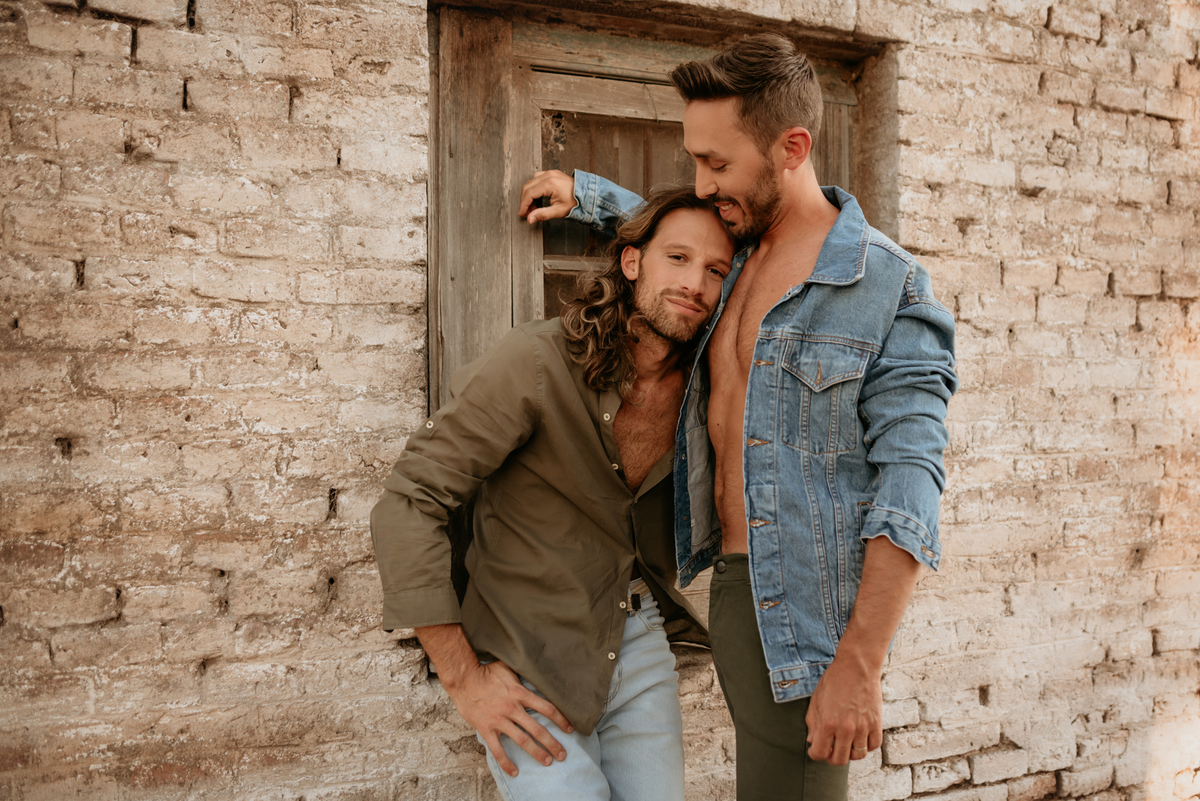 Pareja de hombres. Amor. Conexión. Modelos masculinos. Pareja sobre ventana.