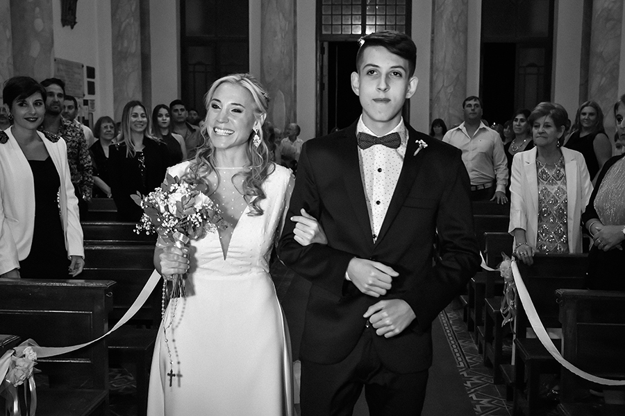 Novia entrando al altar con padrino. Ceremonia religiosa. Vestido de novia para la boda en Santa Fe. Barby Massei.