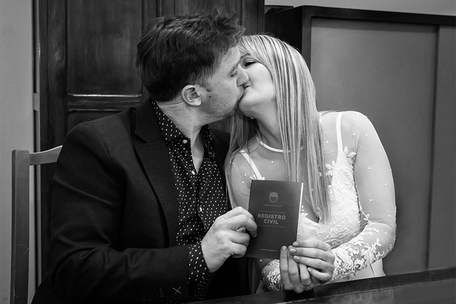 Novios con libreta de matrimonio civil. Beso en la ceremonia de casamiento en Santa Fe. Fotografía blanco y negro de Barby Massei.
