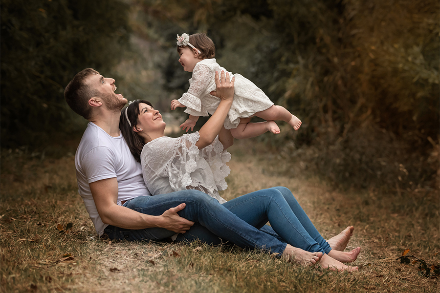 Mamá y papá con Renata en su book de fotos al atardecer en la granja. Mimos y juegos para esta familia en Santa Fe. Barby Massei
