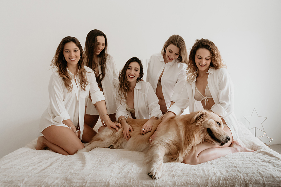 Golden acostado en la cama con amigas en ropa interior. Fotos del día del amigo en San José de la esquina