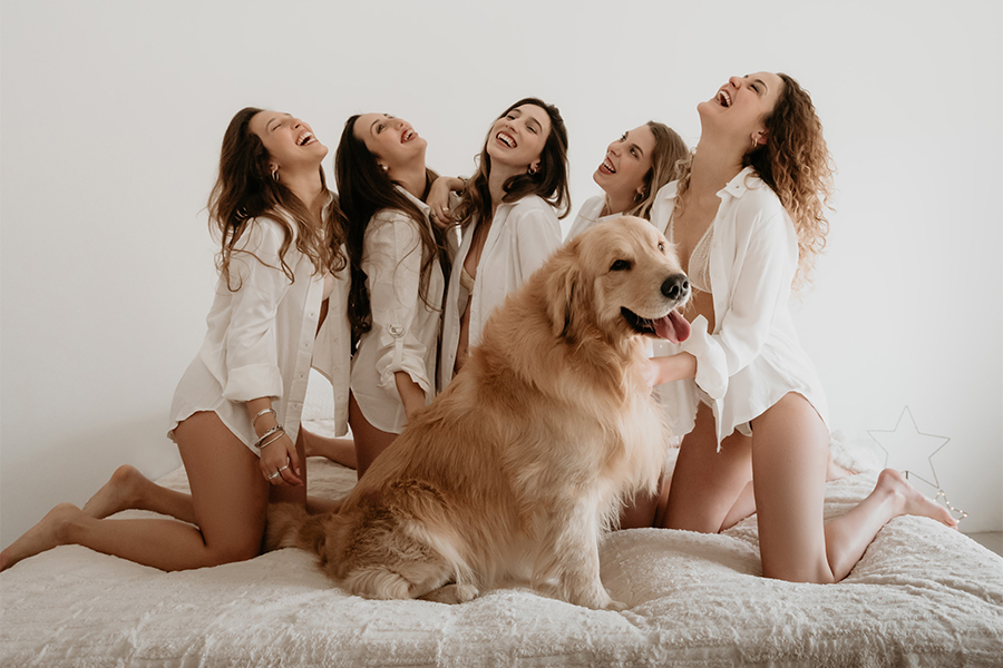 Perro golden dorado en la cama con adolescentes el día del amigo. Foto en Santa Fe de Barby Massei