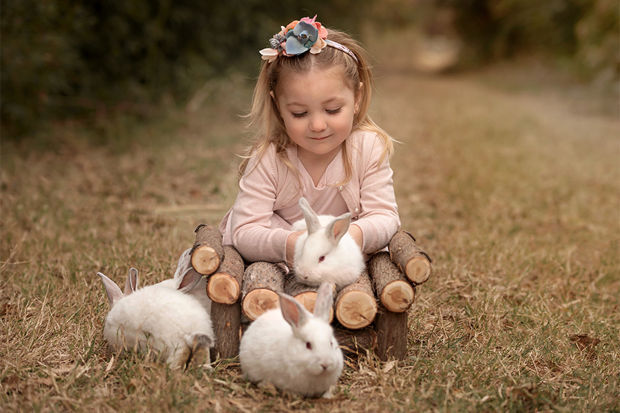 Conejitos blancos y niña con flores en la sesión de fotos en Santa Fe Barby Massei