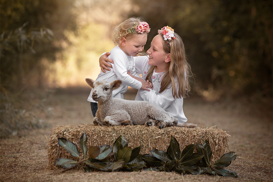 Hermanas con corderito en la tarde en el campo. Sesión de fotos al atardecer en Santa Fe. Fotos de Barby Massei