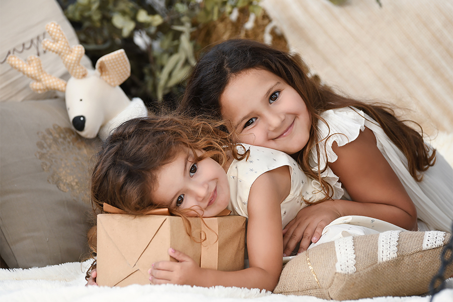 Hermanas en book para navidad. Sesión de fotos navideña con paquete de regalo. San José de la esquina, Santa Fe. Barby Massei fotografía