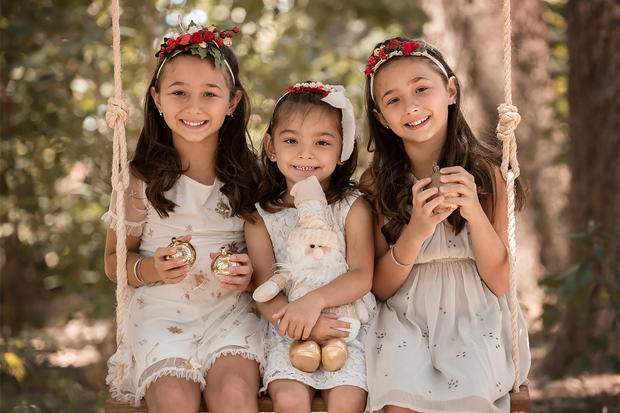 Hamaca decorada con flores blancas y rojas en el campo. Atardecer para el book de fotos de navidad. Barby Massei.
