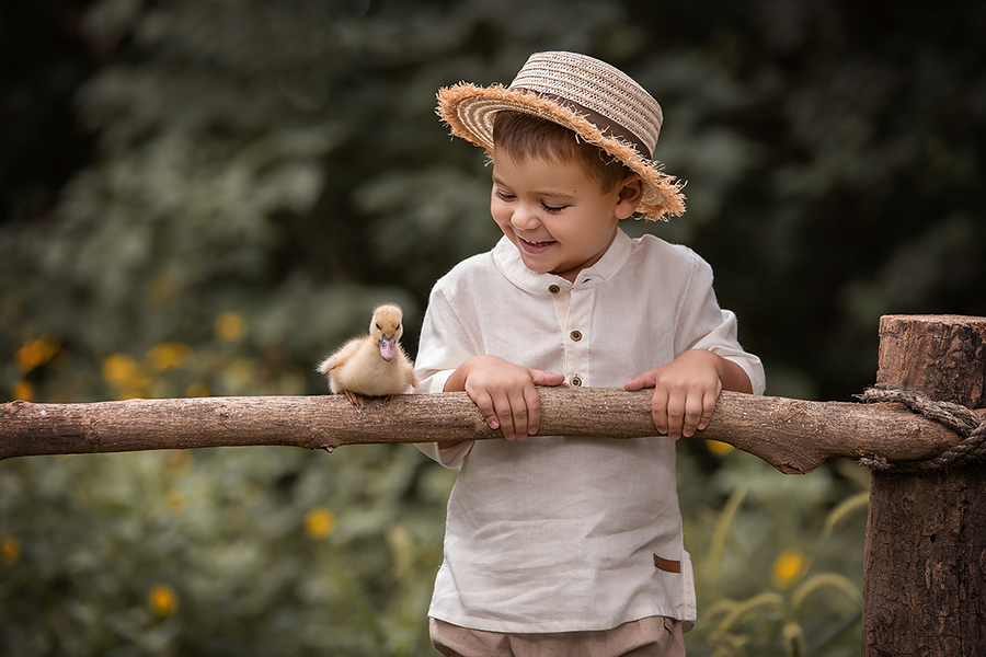 Fotos de familia. Niño en su book con Barby Massei con pollito en la tranquera. 