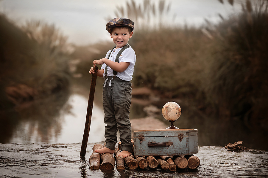 Niño en la balsa en el campo al atardecer para el book de fotos de San José de la Esquina. Barby Massei fotos.