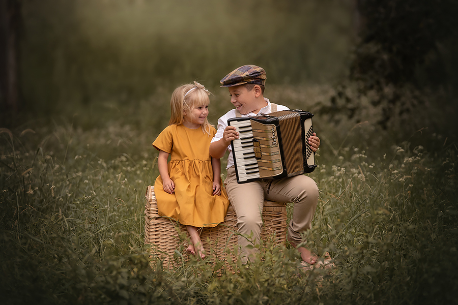 Hermanitos compartiendo música y sonrisas en el campo. Sesión de fotos para el book de Barby Massei.