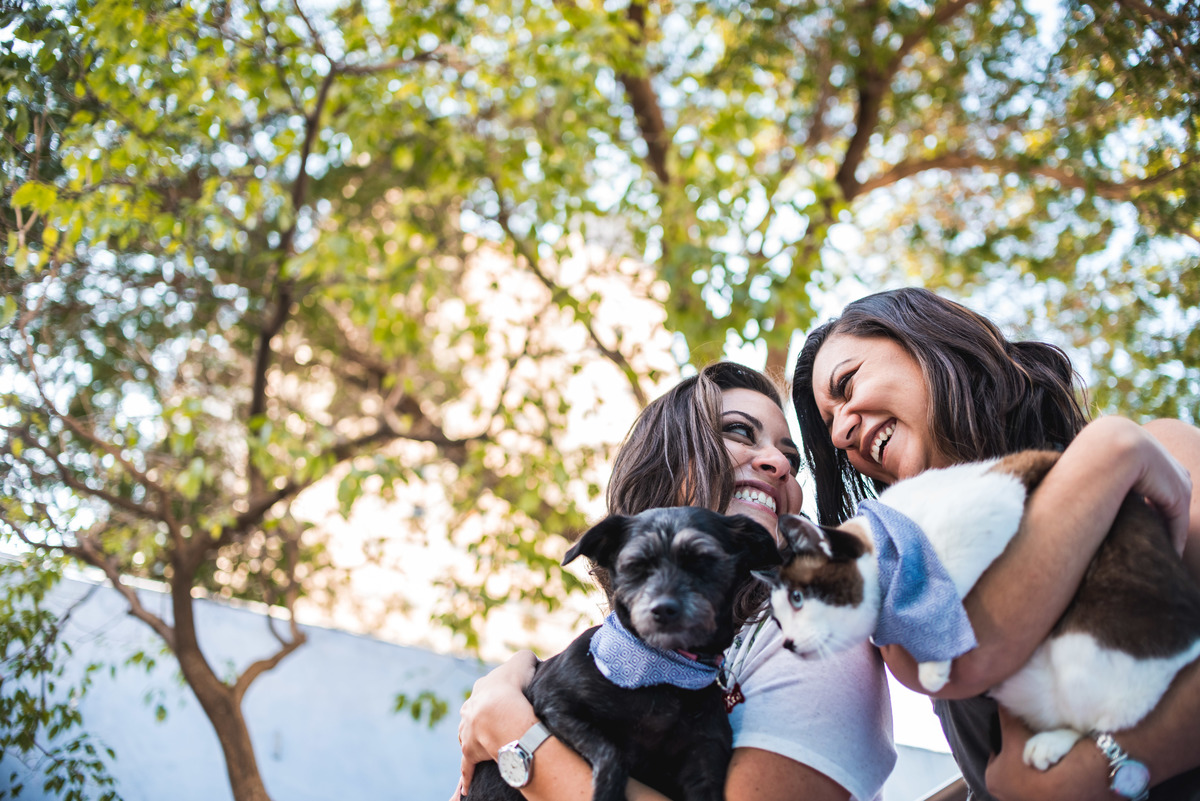 casal sorrindo abraçadas com seus pets