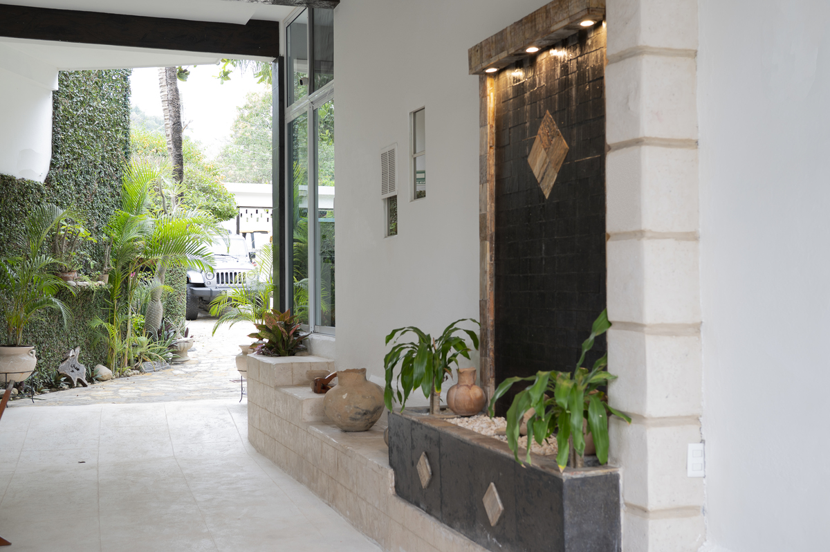 Entrada que recibe con una estética limpia, integrando naturaleza y arquitectura