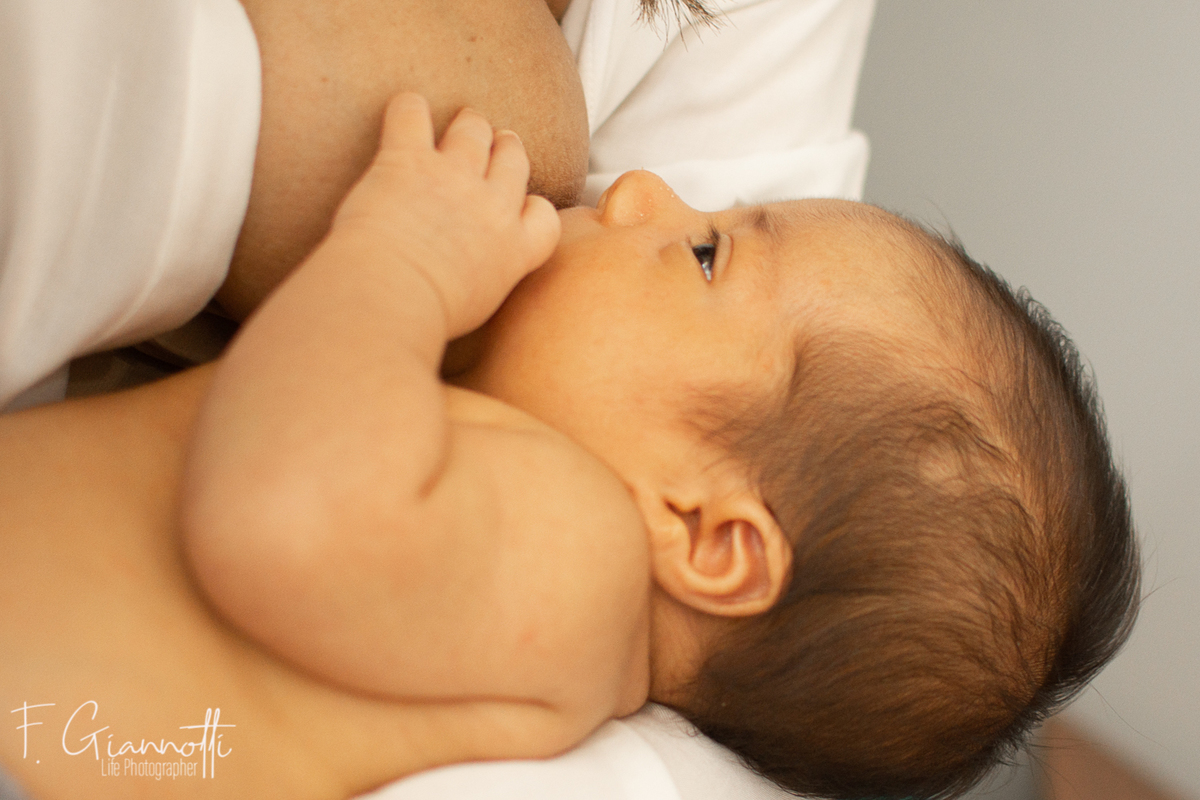 Momento de lactancia en sesión newborn lifestyle en casa