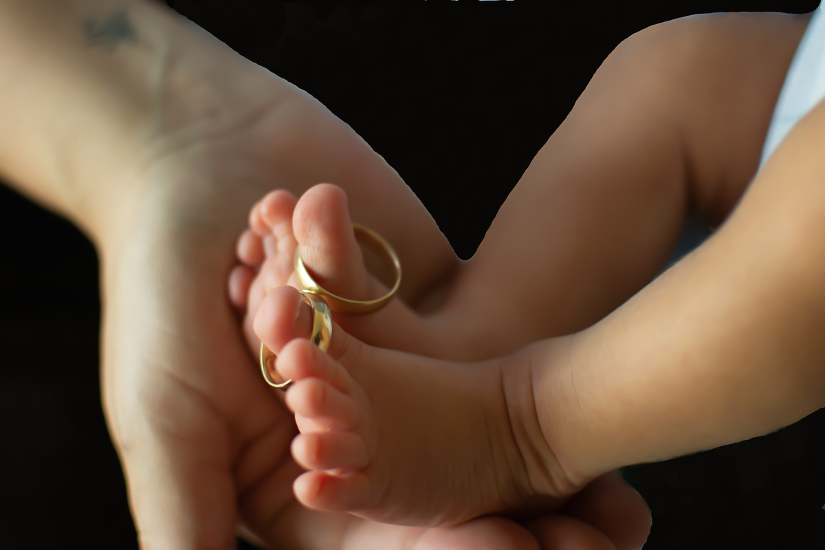 Detalle de anillos en pies del bebé en sesión newborn lifestyle