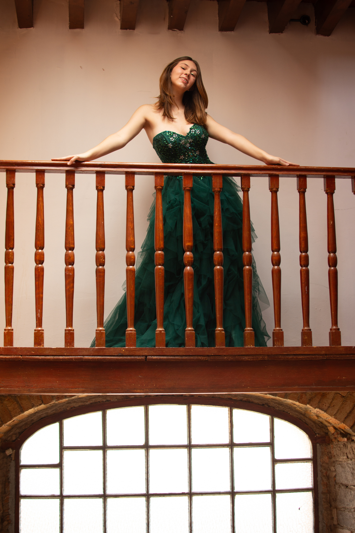 Sesión de XV en balcón colonial en Querétaro. Vestido verde con presencia elegante y arquitectura tradicional.