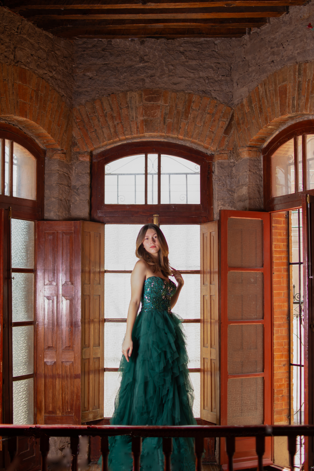 Sesión de XV en balcón de madera en Querétaro. Contraste entre lo rústico y la elegancia del vestido.