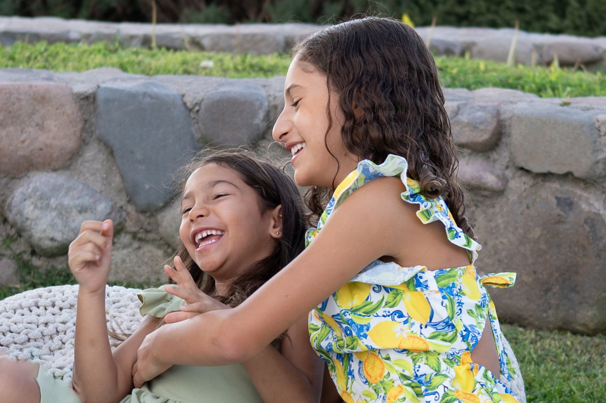 Retrato de hermanas compartiendo un momento especial durante una sesión de fotos familiar.