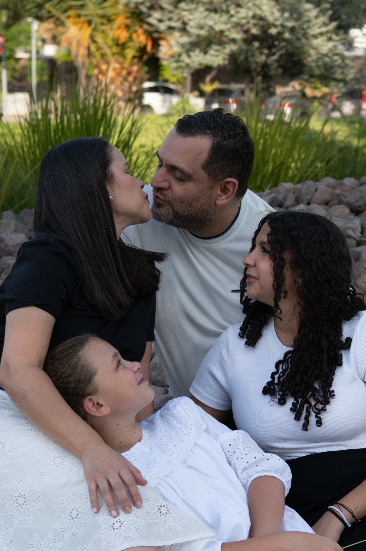 Padres e hijas juegan y ríen mientras recorren el parque durante una sesión familiar en Querétaro. Fotografías espontáneas que documentan momentos reales en familia.