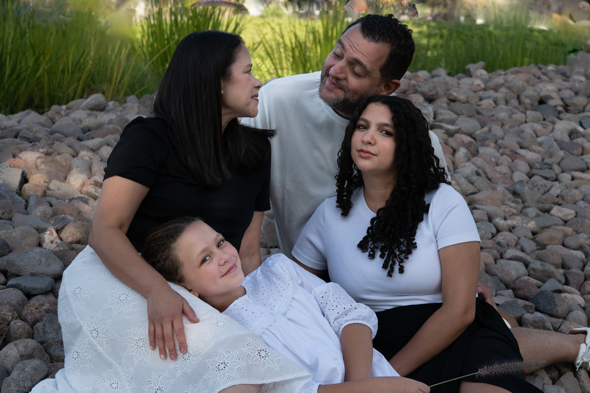 Un momento de complicidad entre la pareja mientras disfrutan de la sesión con sus hijas. Fotografías sencillas y auténticas que conservan recuerdos para toda la vida.