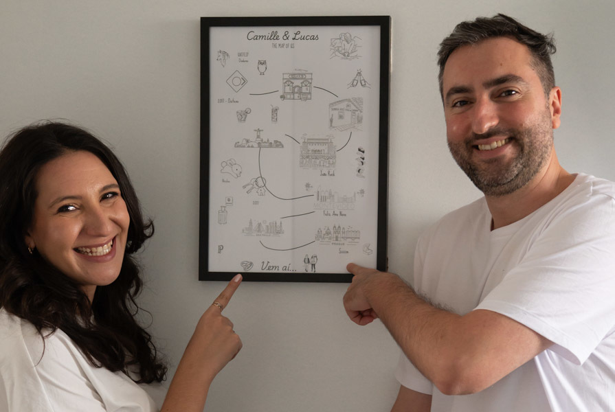 Cami y Lucas sonriendo junto a un cuadro de su sala. Sesión de preboda en casa en Querétaro.en casa en Querétaro.