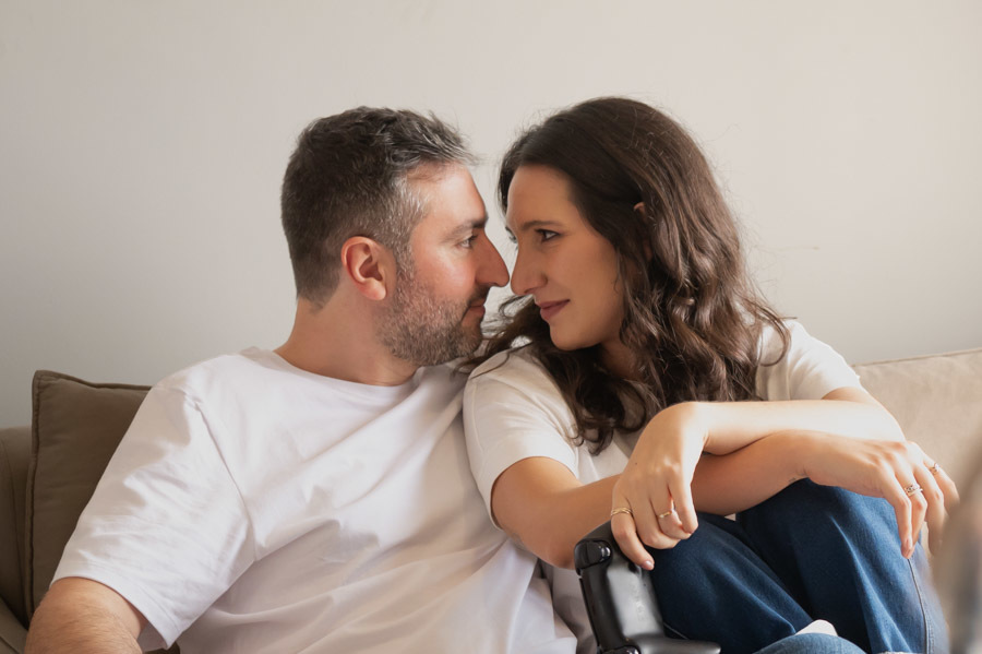 Cami y Lucas sentados frente con frente en el sofá de su sala. Fotos de preboda en casa en Querétaro.