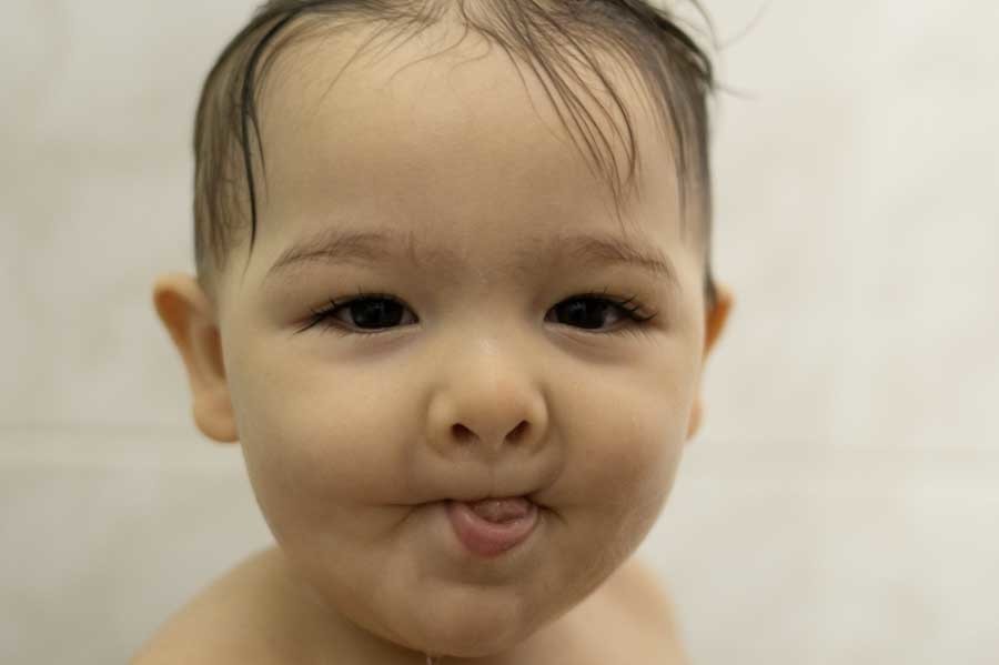 Bebé de un año dentro de la tina, sonriendo. Sesión de bebé en casa en Querétaro.