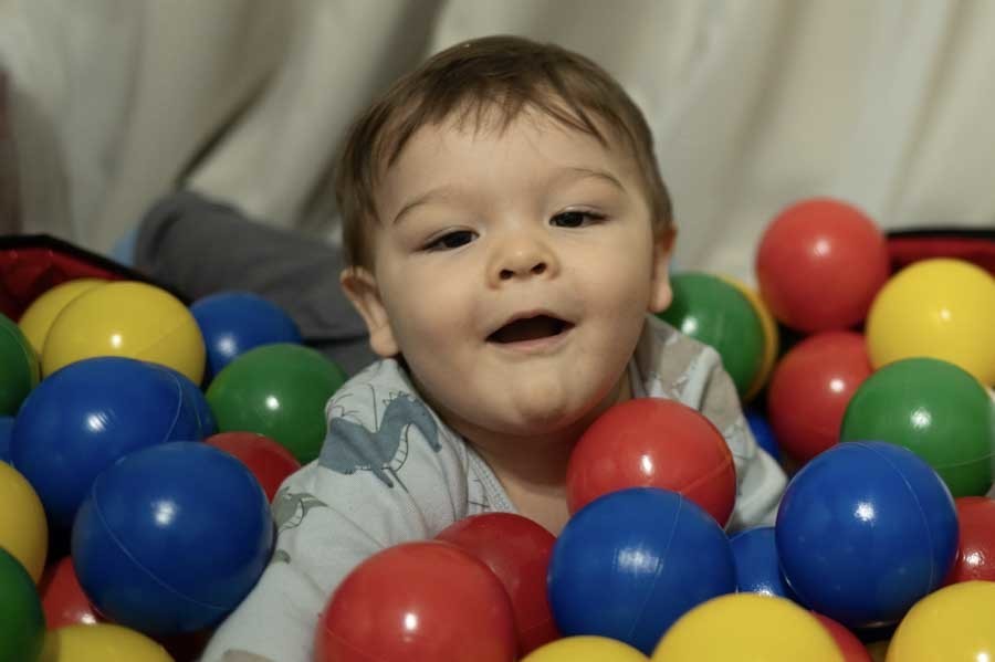Bebé de un año jugando en la alberca de pelotas de su sala. Sesión de primer año en casa en Querétaro.