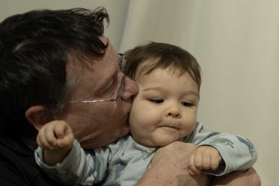 Bebé de un año en brazos de su abuelo. Sesión de primer año en casa en Querétaro.