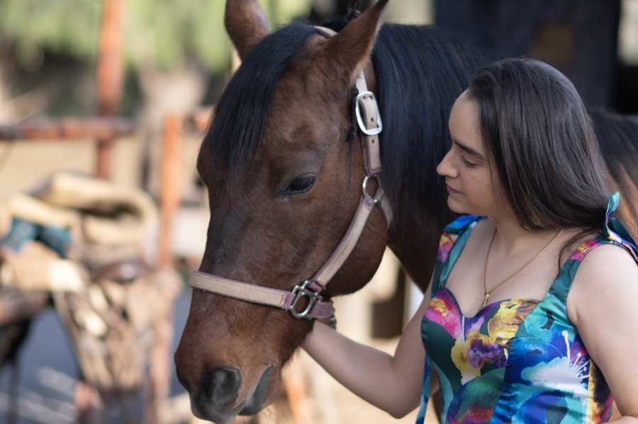 Retrato de quinceañera acariciando a su caballo, sesión de XV años con caballos