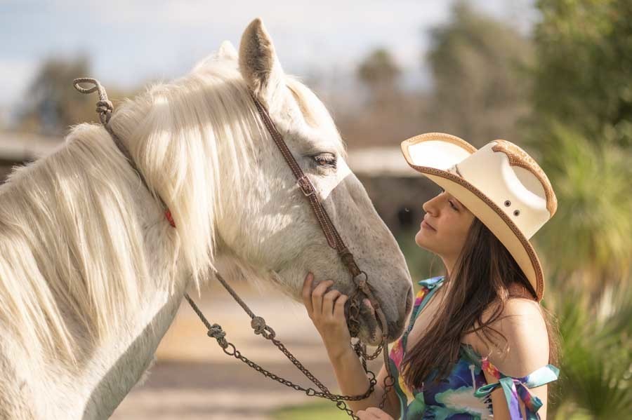 Detalle de sombrero vaquero y caballo blanco en una sesión de XV años campestre