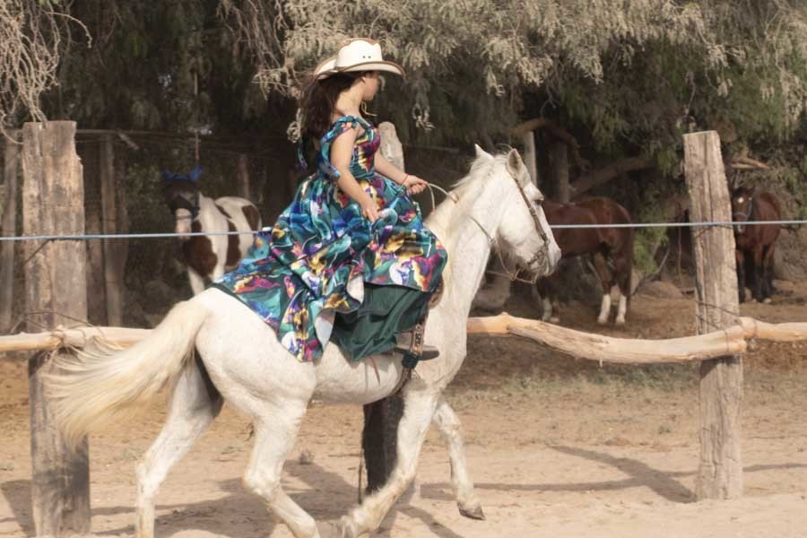 Quinceañera cabalgando un caballo blanco en el campo, sesión de XV años en Querétaro