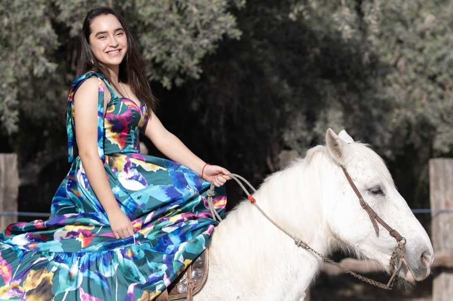 Vestido floral de XV años extendido sobre un caballo blanco, sesión de quinceañera
