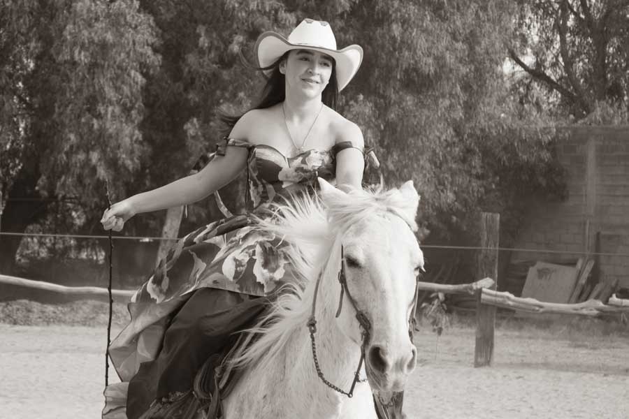 Fotos de XV años en blanco y negro: quinceañera con sombrero vaquero cabalgando