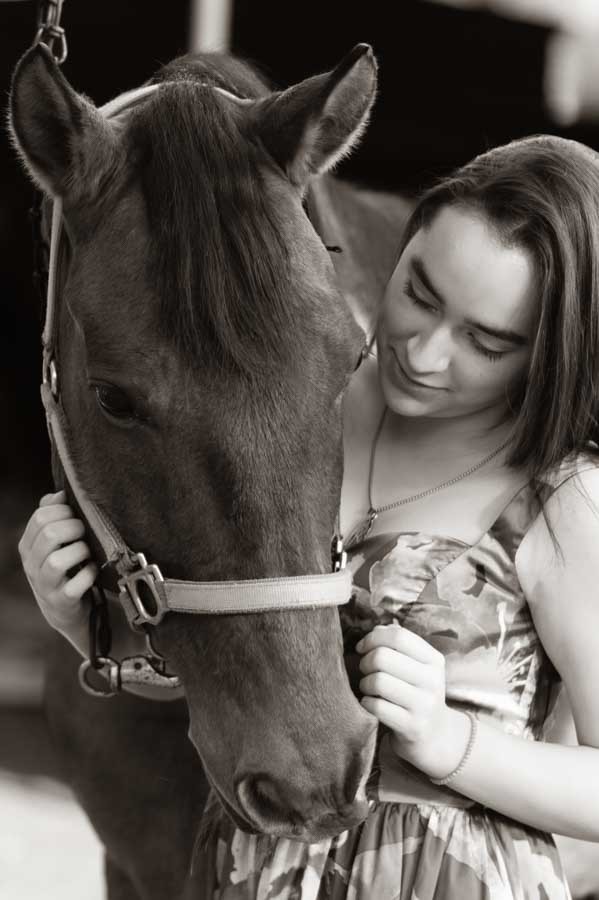 Retrato de quinceañera en blanco y negro abrazando a su caballo