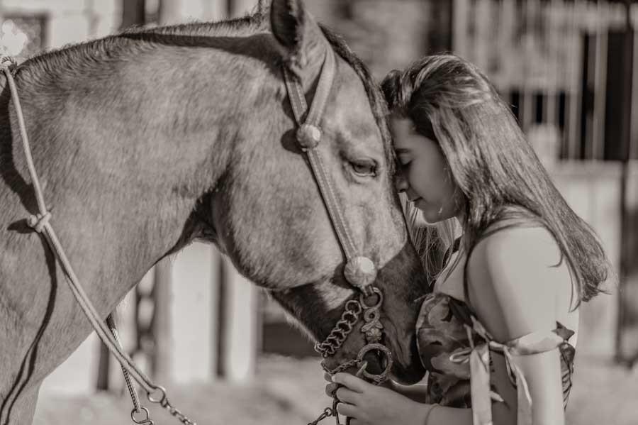 Sesión de XV años en blanco y negro: quinceañera junto a su caballo