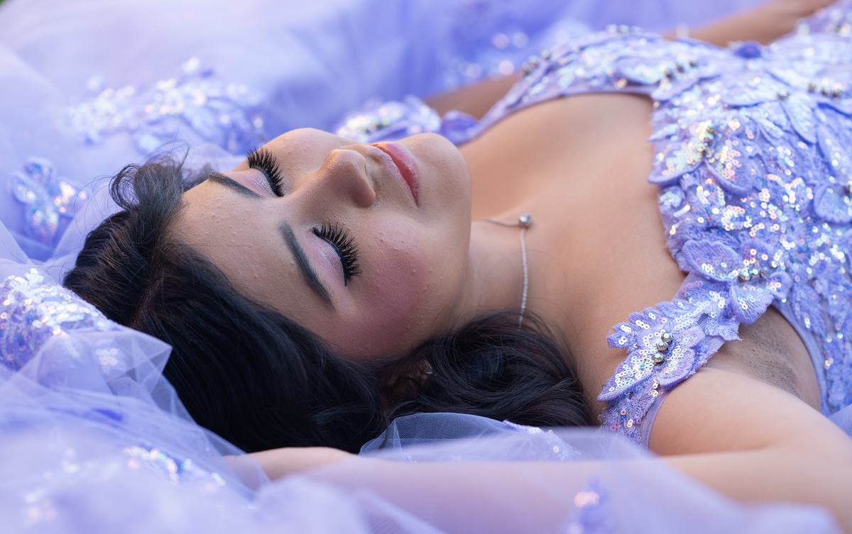 Retrato de XV años: quinceañera recostada sobre su vestido lila