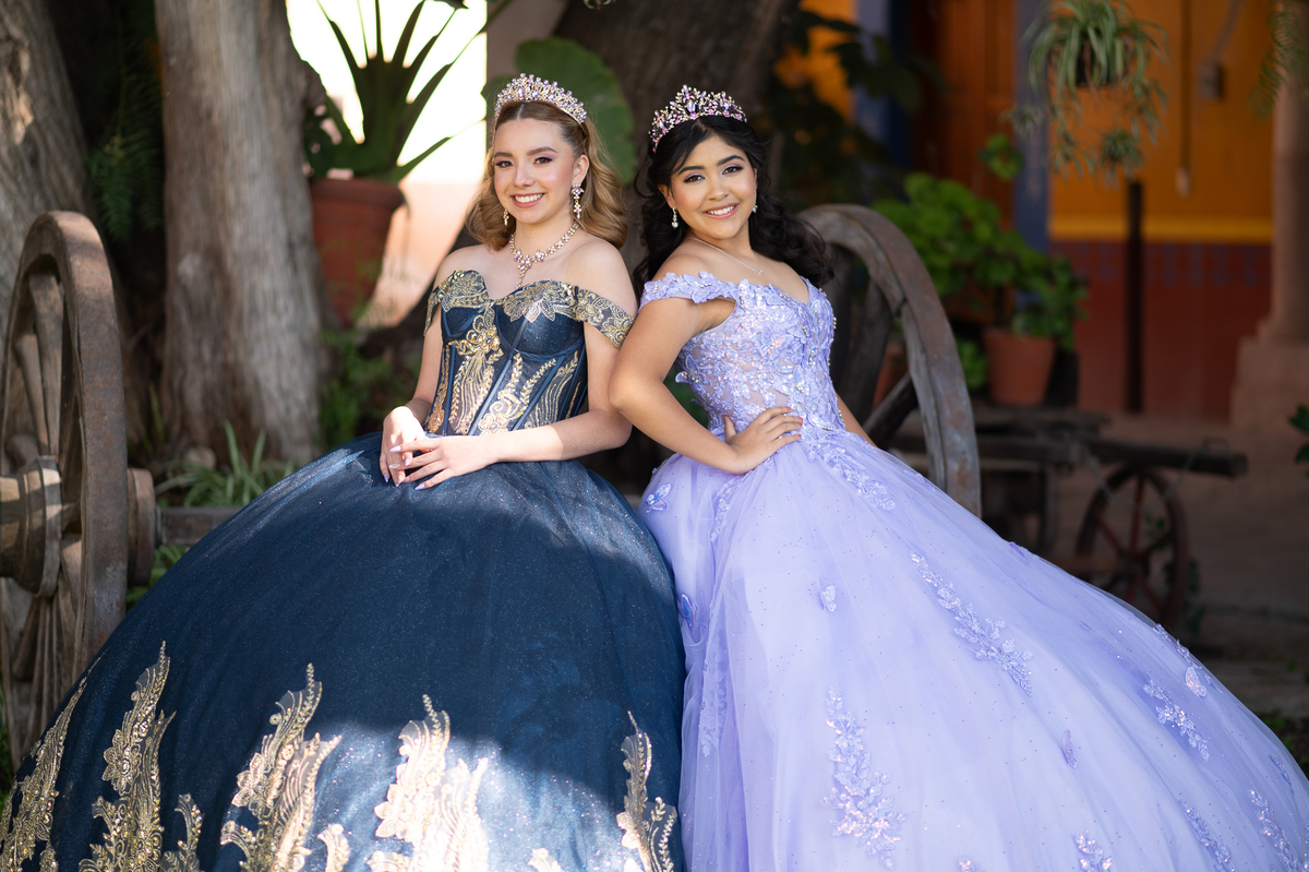 XV años tradicional: dos quinceañeras sentadas en el jardín de una hacienda