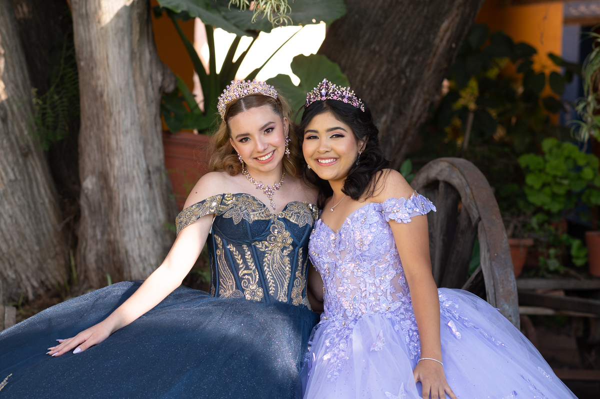 Dos quinceañeras sonriendo juntas en su sesión de XV años en hacienda