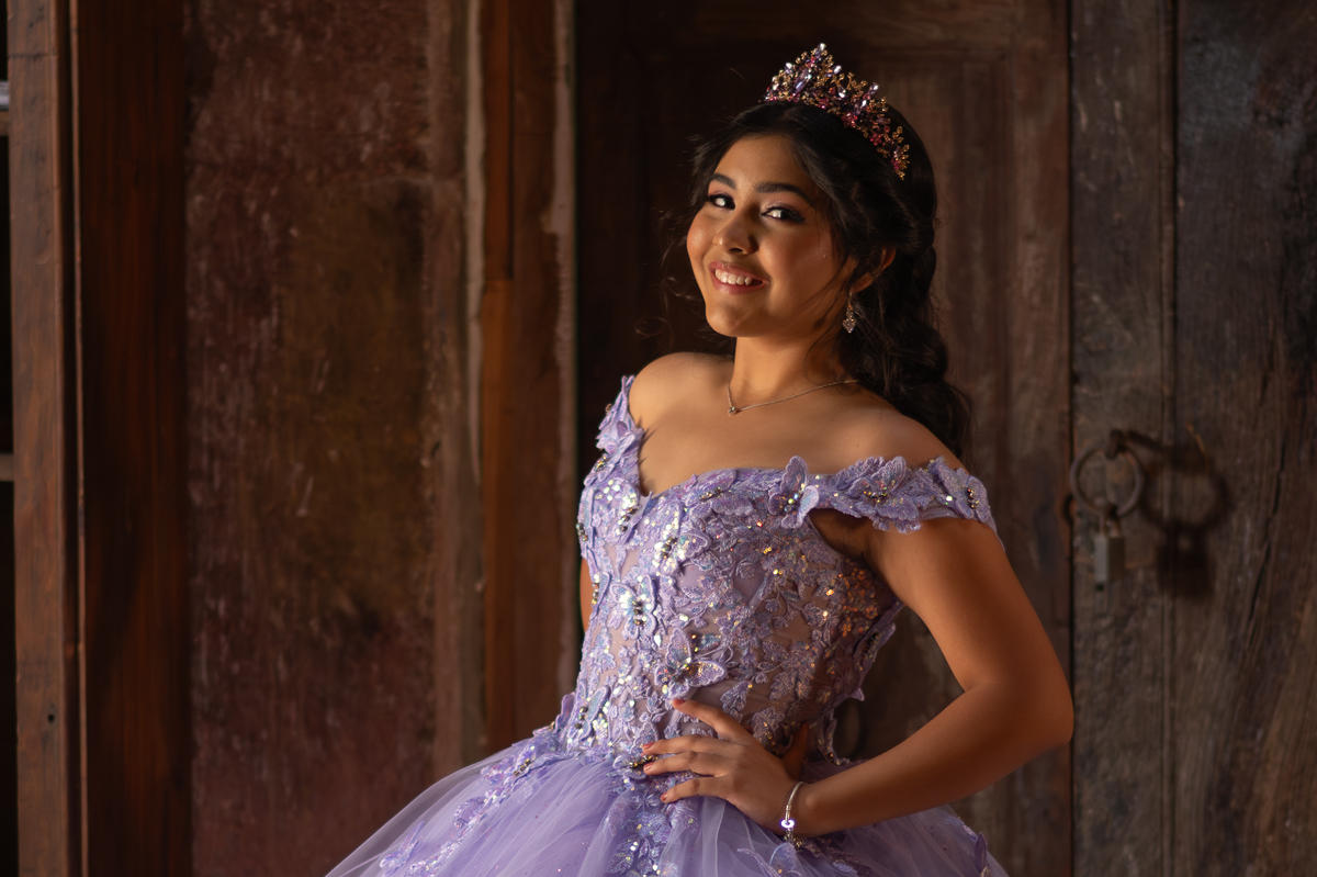 Quinceañera con vestido lila y corona en su sesión de XV años en hacienda