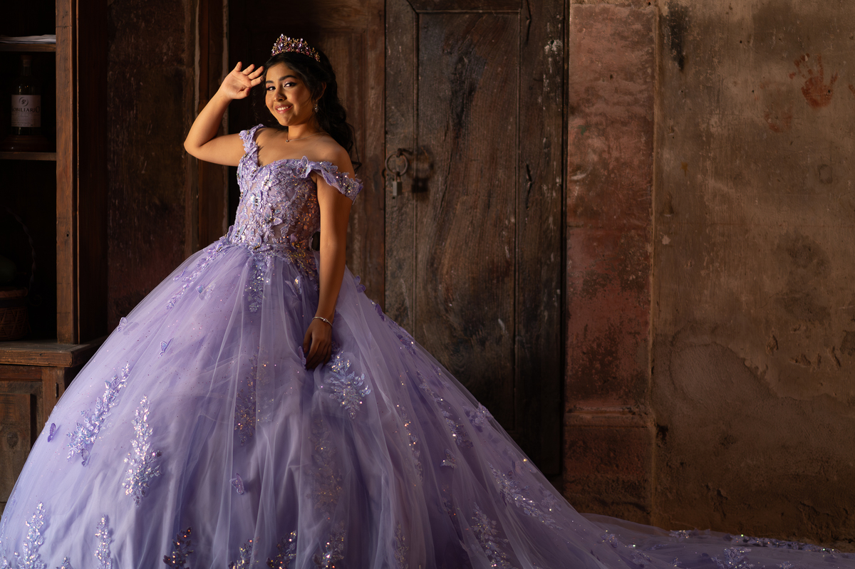 Vestido de XV años lila con la falda extendida, sesión de quinceañera en espacio campestre