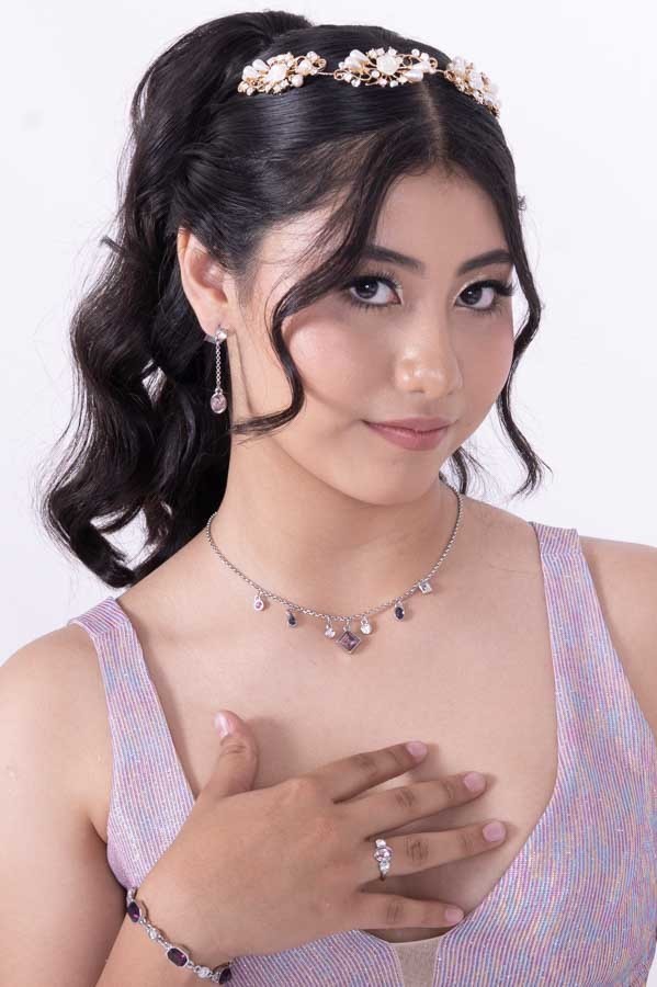 Retrato de quinceañera con peinado de ondas y corona de flores en estudio