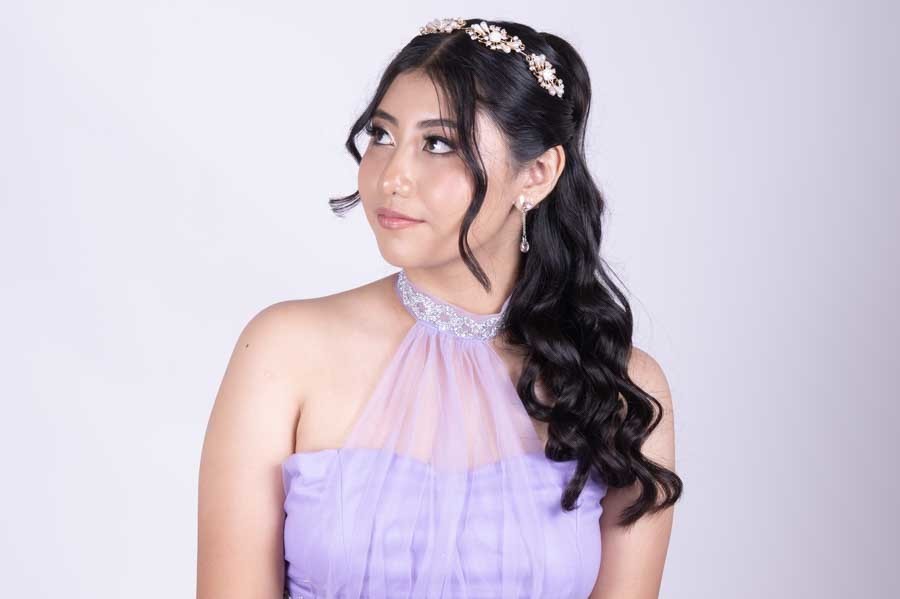 Quinceañera con vestido lila mirando hacia un lado, retrato de XV años en estudio
