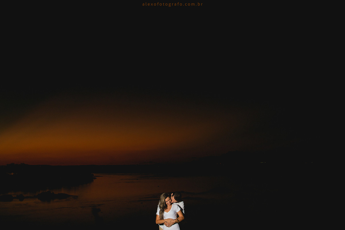 foto linda do noivo abraçando a noiva por trás e cheirando seu pescoço