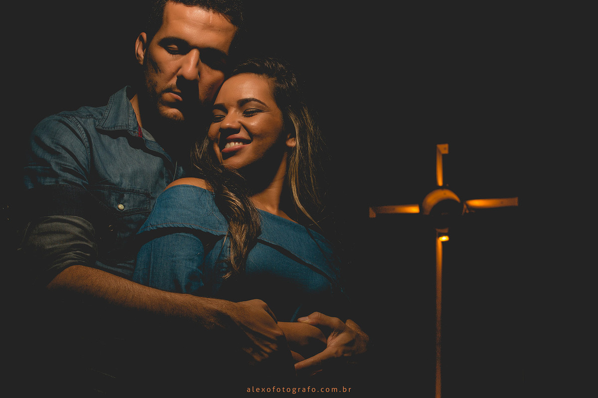 noivos abraçados na praça dom malan em petrolina com a cruz ao fundo da foto