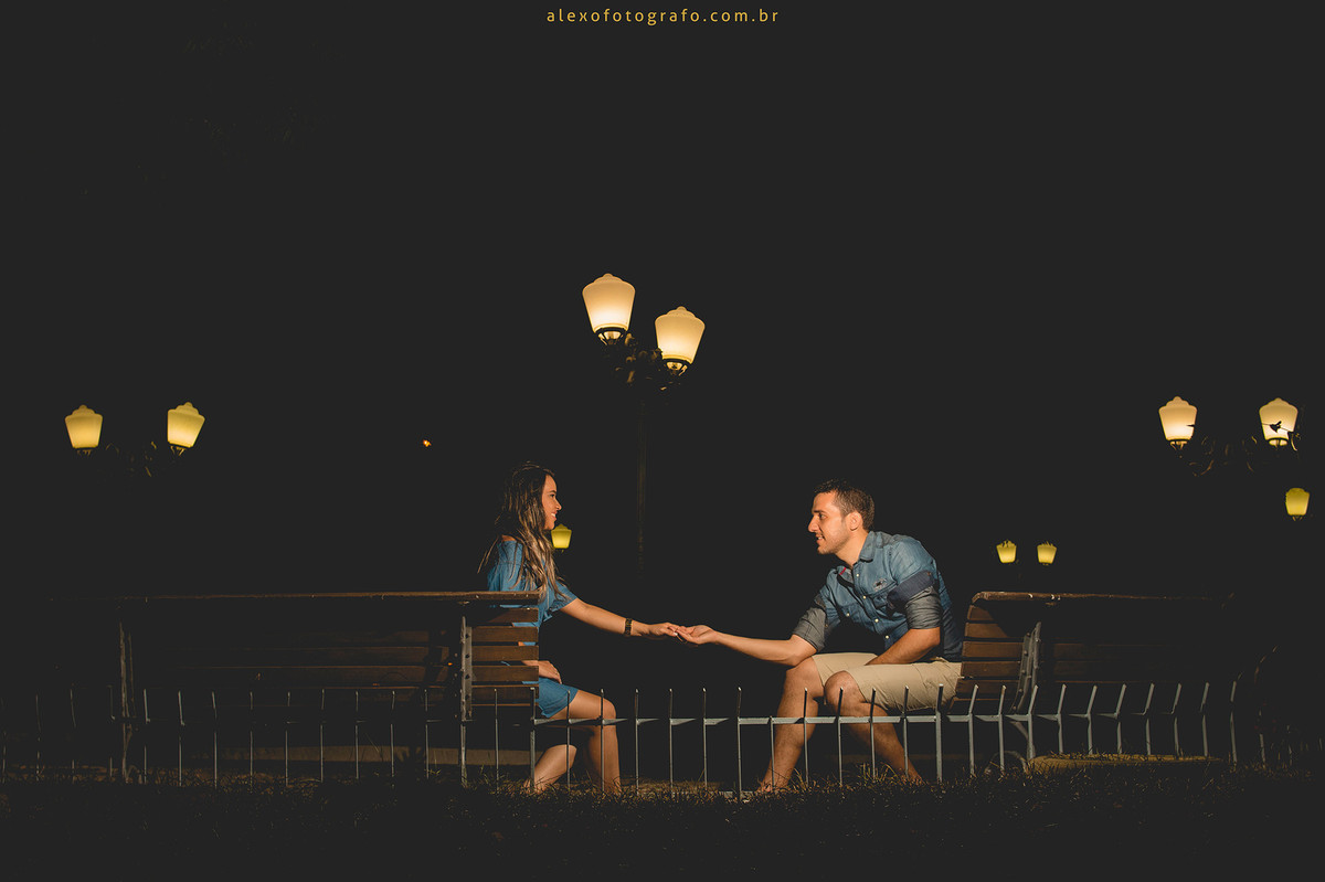 noivos sentados nos bancos da praça dando as mãos