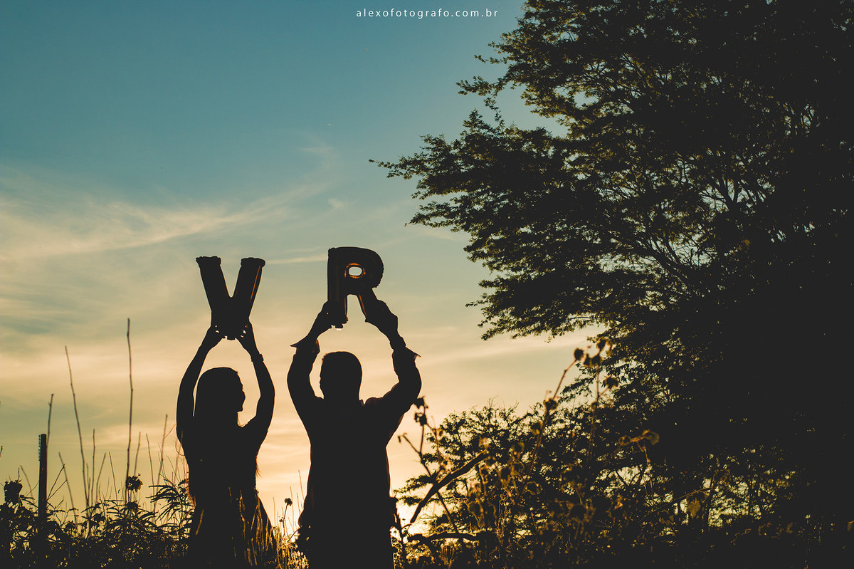 silhueta do casal segurando balões com as iniciais de seus nomes