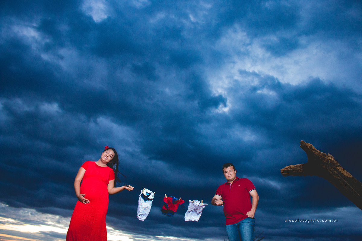 ensaio de gestante, casal segurando o varal com roupinhas do bebê