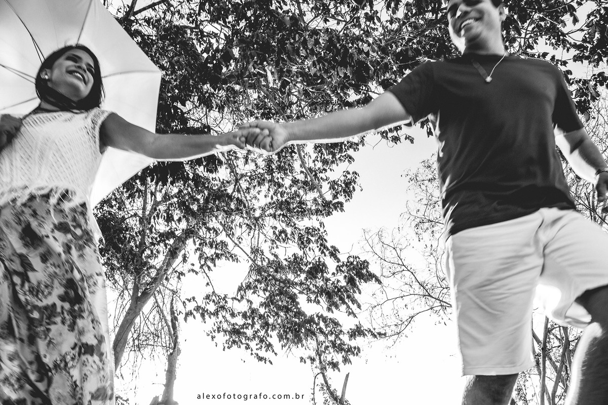 casal de mãos dadas correndo, se olhando e sorrindo 